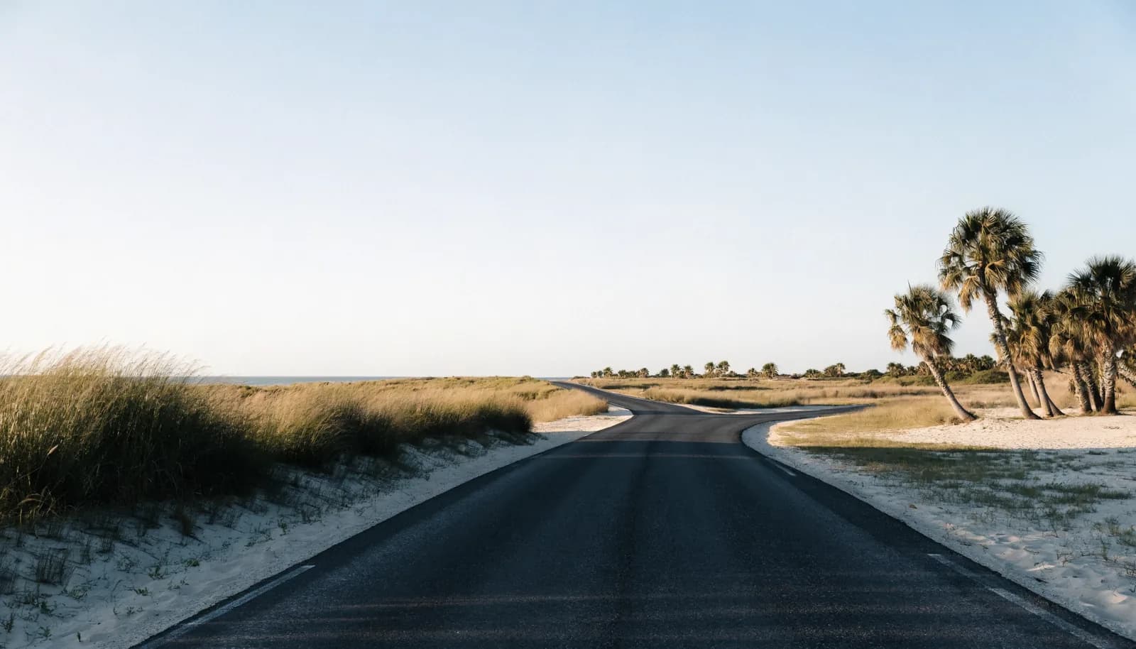 A fork in a quiet coastal road under a clear sky